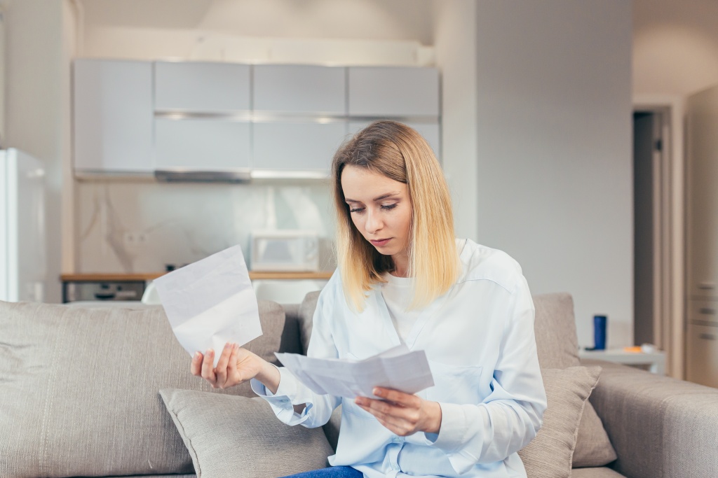 worried-housewife-pays-inflated-bills-while-sitting-sofa-home-frustrated-with-work-monthly-income.jpg бумаги