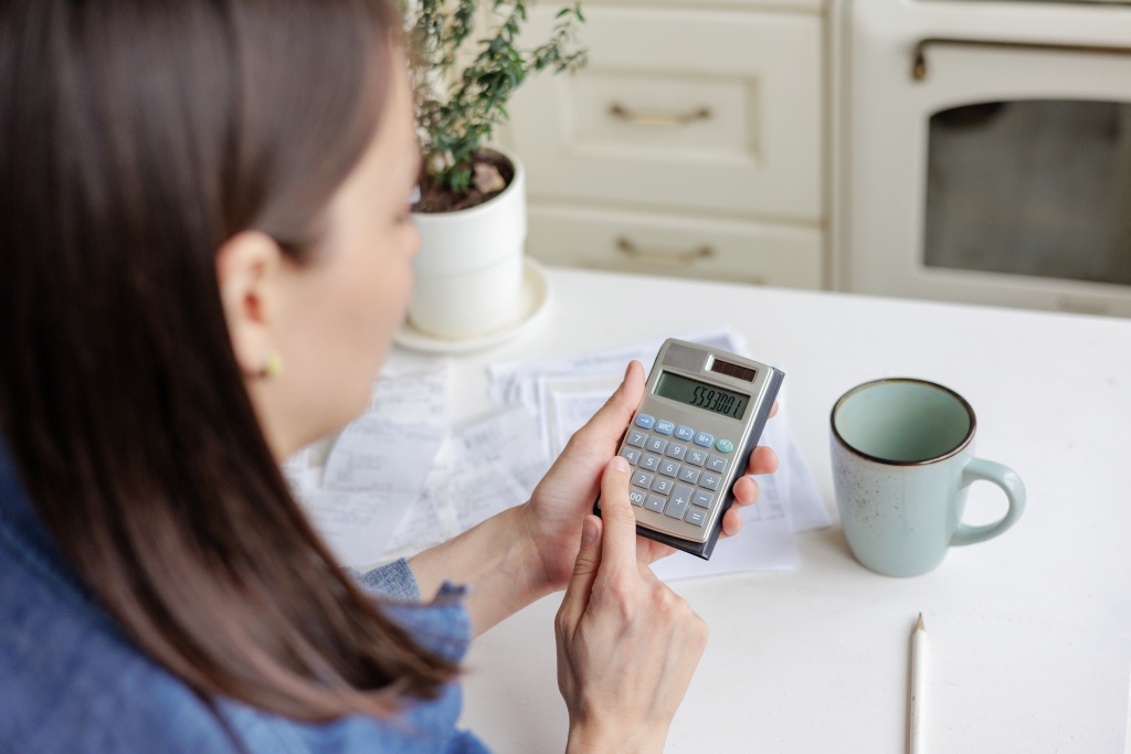 woman-pays-utility-bills-and-writes-checks-a-euro-2023-11-27-05-26-30-utc.jpg девушка считает на калькуляторе